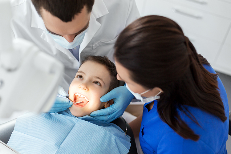 Child with dental team examining teeth.